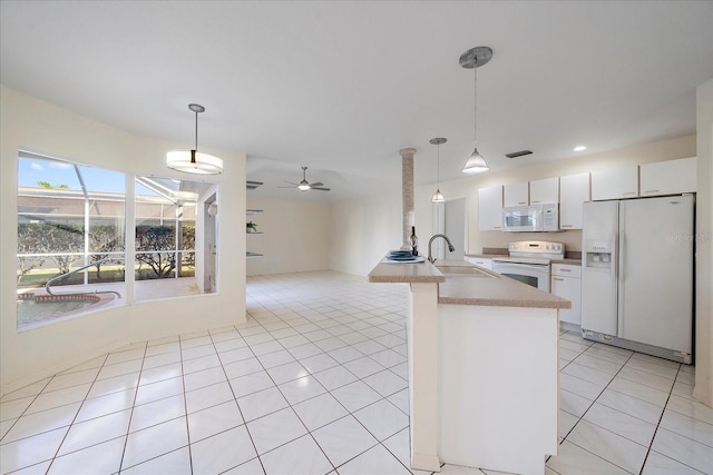 kitchen featuring light tile patterned floors, a peninsula, white cabinets, white appliances, and a sink