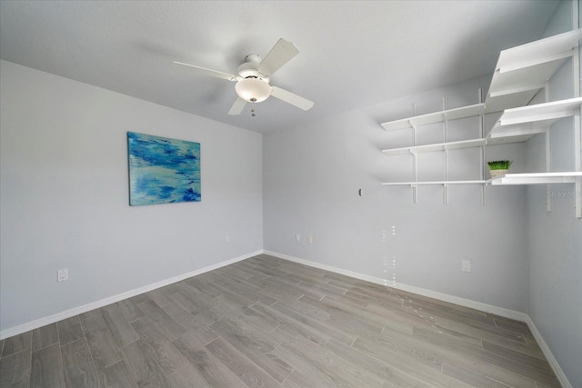 spare room with a ceiling fan, baseboards, and wood finished floors