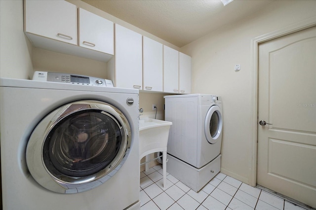 laundry room featuring light tile patterned floors, washer and clothes dryer, and cabinets