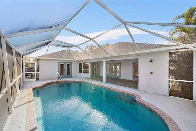 view of pool featuring a patio area, glass enclosure, and french doors