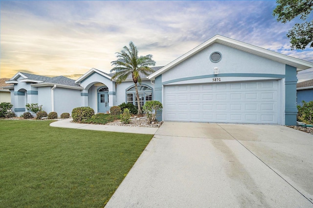 ranch-style home featuring stucco siding, a garage, concrete driveway, and a front lawn