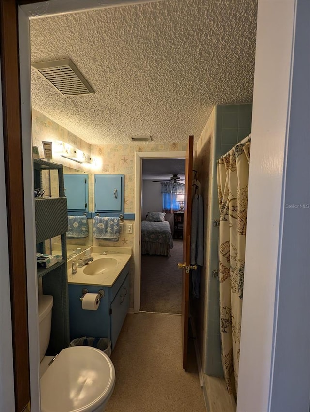 bathroom with a shower with shower curtain, vanity, toilet, and a textured ceiling