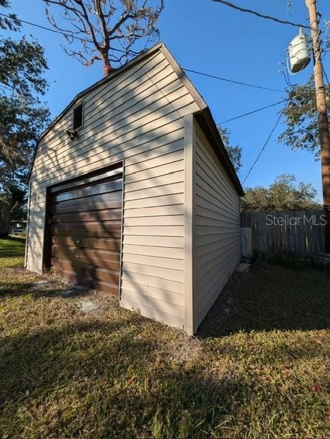 view of home's exterior featuring a yard, a garage, and an outbuilding