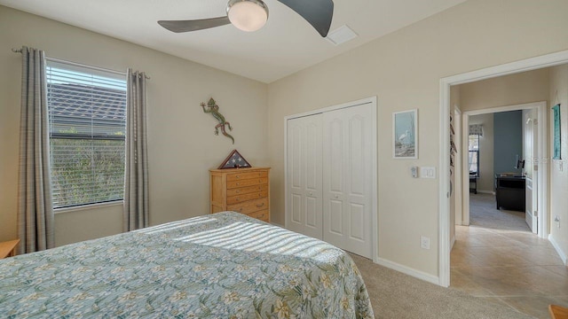 carpeted bedroom featuring ceiling fan and a closet