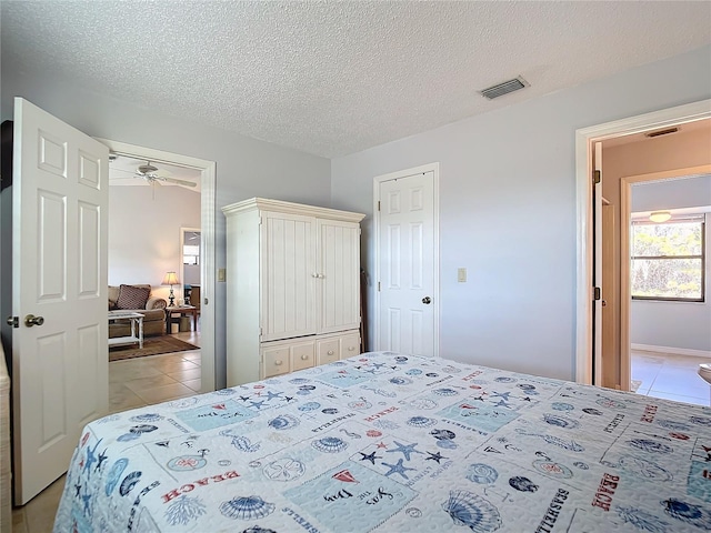 bedroom with a textured ceiling and light tile patterned flooring