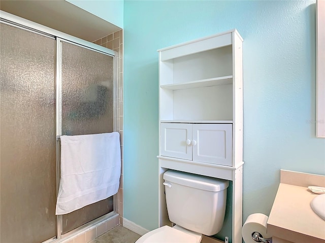 bathroom featuring a shower with door, vanity, and toilet