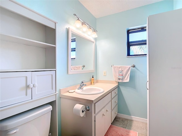 bathroom featuring vanity, tile patterned flooring, a textured ceiling, and toilet