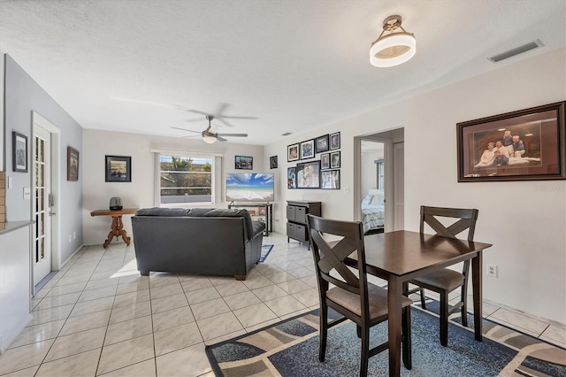 tiled dining area with ceiling fan, french doors, and a textured ceiling