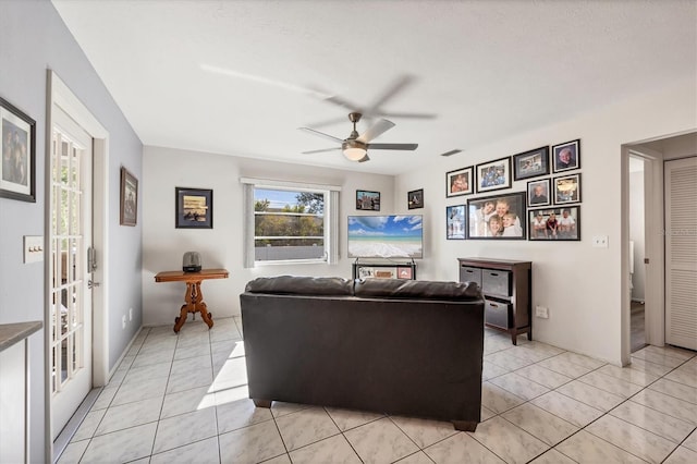 living room with ceiling fan and light tile patterned floors