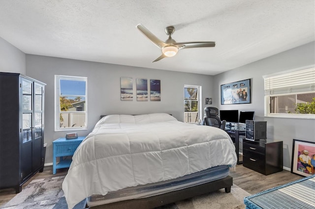 bedroom featuring hardwood / wood-style flooring, ceiling fan, and a textured ceiling