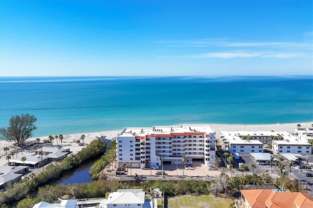 drone / aerial view with a water view and a beach view