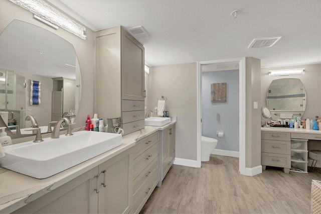 bathroom featuring wood-type flooring, toilet, and vanity