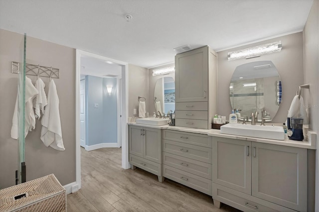 bathroom featuring hardwood / wood-style flooring, vanity, and walk in shower