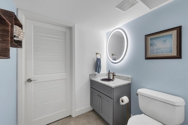 bathroom with vanity, toilet, and tile patterned flooring