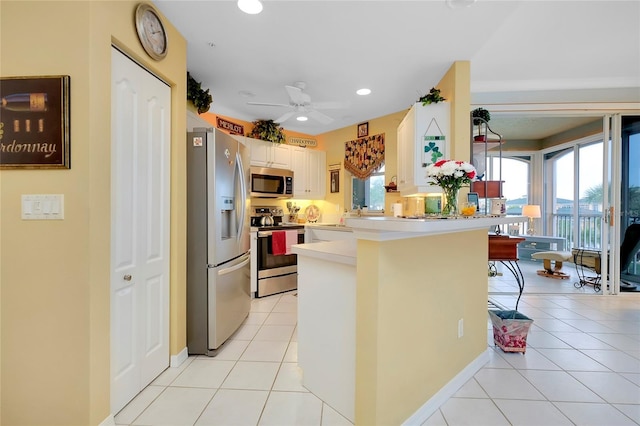 kitchen featuring stainless steel appliances, light tile patterned flooring, a breakfast bar, and kitchen peninsula