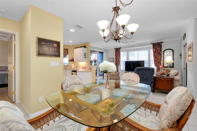 dining room with ornamental molding, light tile patterned floors, and an inviting chandelier