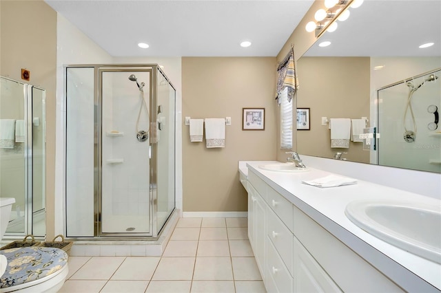 bathroom with tile patterned floors, toilet, a shower with door, and vanity