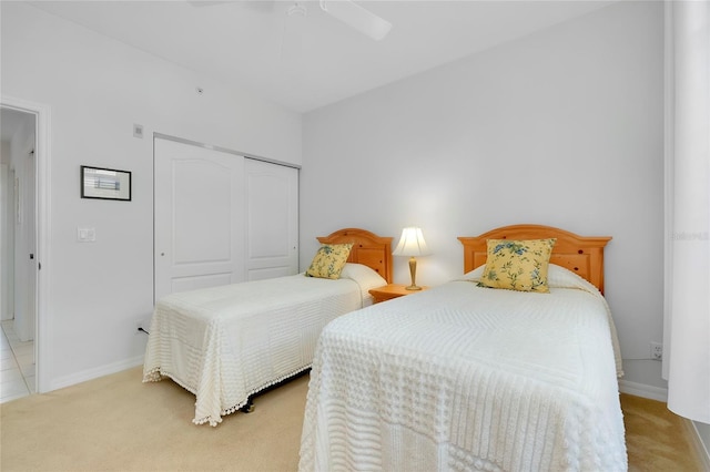 carpeted bedroom with ceiling fan and a closet