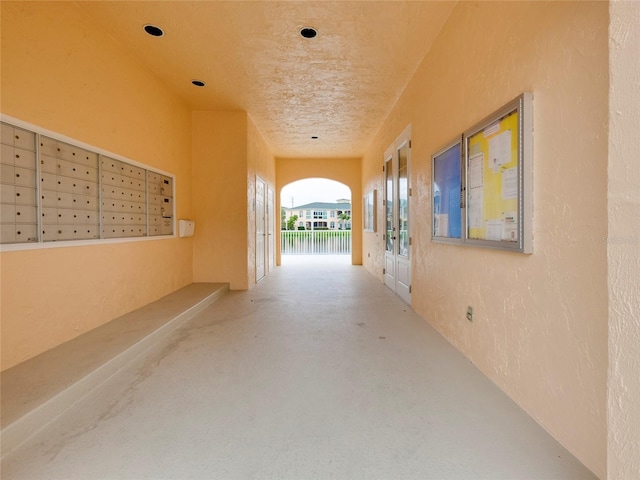 corridor with concrete flooring and mail boxes