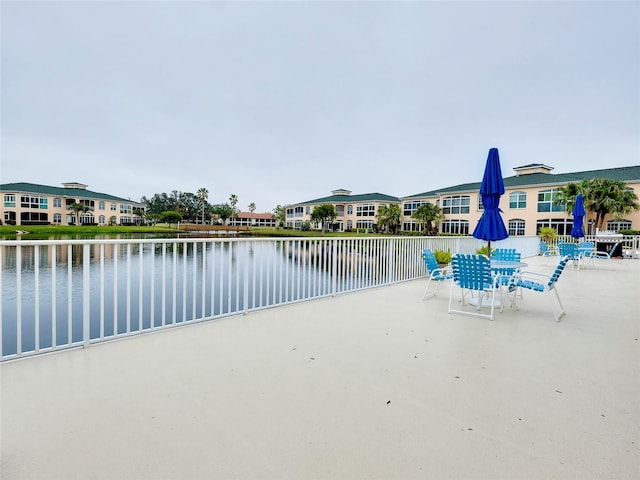 view of pool featuring a patio and a water view