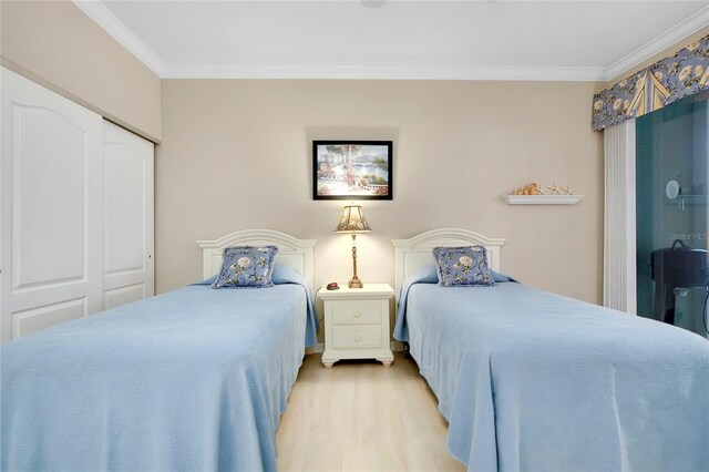 bedroom featuring a closet, ornamental molding, and light hardwood / wood-style floors