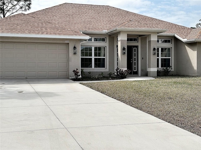 view of front of home with a garage and a front lawn