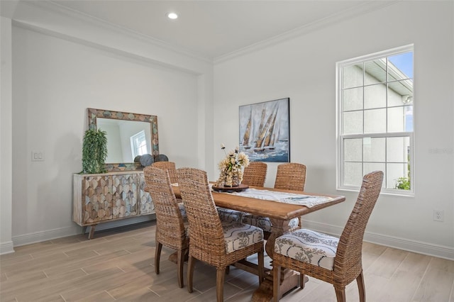 dining space featuring ornamental molding and light hardwood / wood-style floors