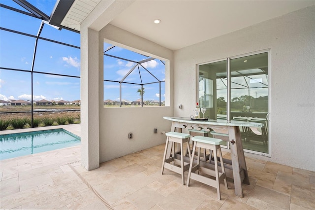 view of patio featuring a bar and a lanai