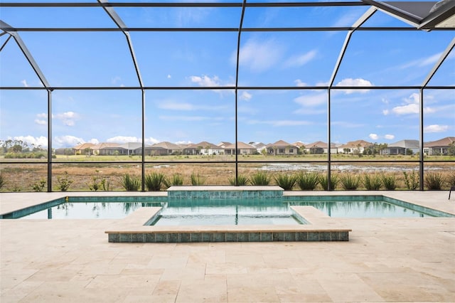 view of pool featuring glass enclosure and a patio area