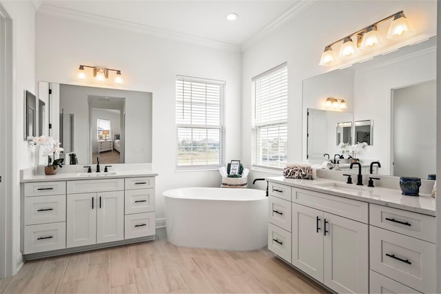 bathroom with vanity, hardwood / wood-style floors, ornamental molding, and a bath