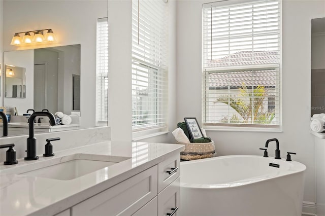 bathroom featuring vanity and a bath