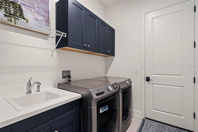 laundry room featuring cabinets, sink, and washer and clothes dryer