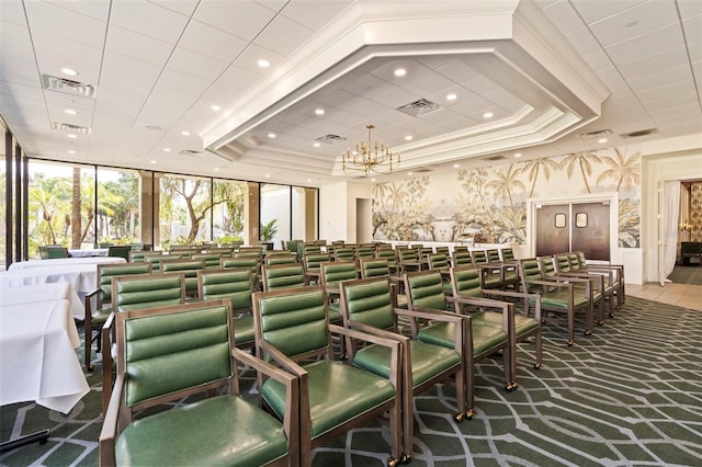 cinema with a tray ceiling, crown molding, and a chandelier