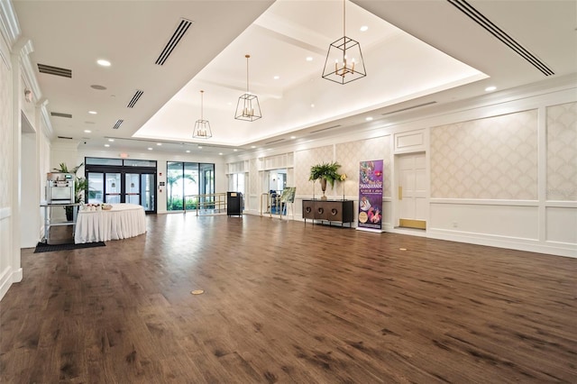 interior space featuring dark hardwood / wood-style flooring, a tray ceiling, and crown molding