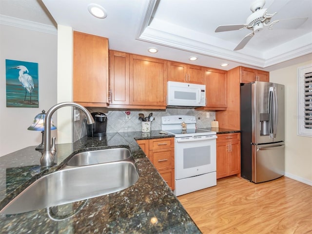 kitchen with sink, crown molding, light hardwood / wood-style flooring, a raised ceiling, and white appliances