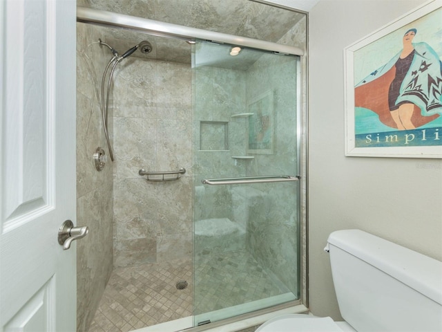 bathroom with toilet and a shower with shower door