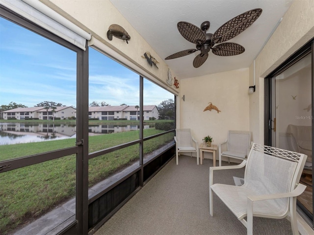 sunroom with a water view and ceiling fan