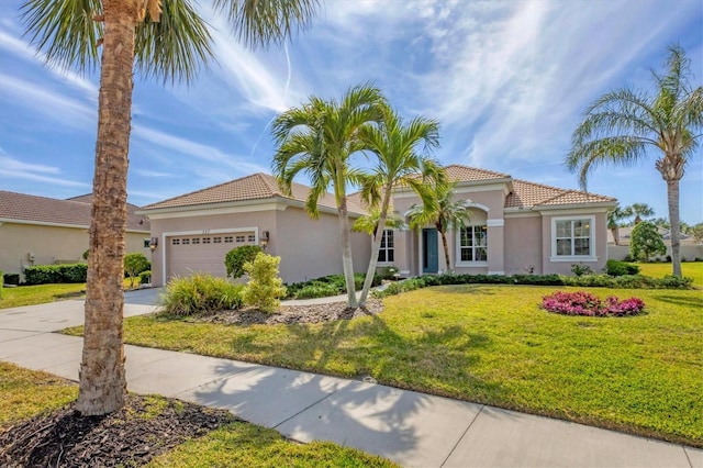 mediterranean / spanish home featuring a garage and a front yard