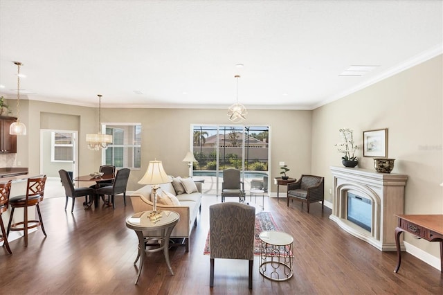 living room featuring dark wood-type flooring, crown molding, and a notable chandelier