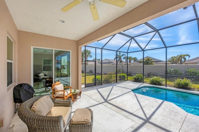 view of swimming pool featuring a patio, ceiling fan, and glass enclosure