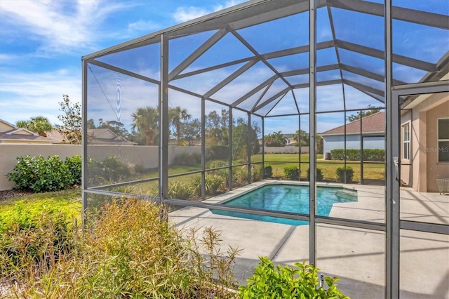 view of swimming pool featuring a patio and glass enclosure