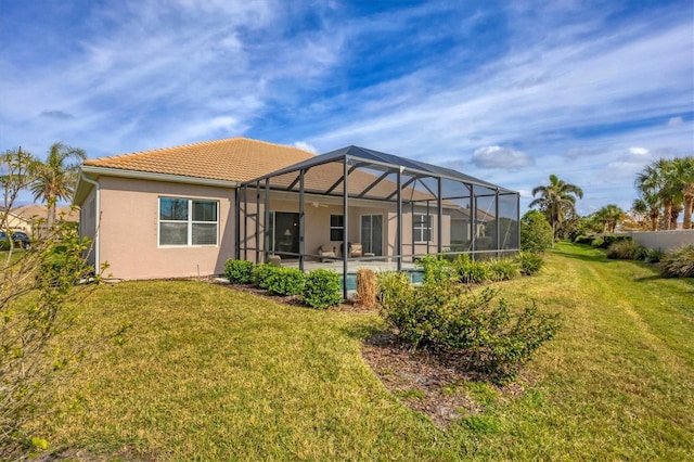 rear view of property with a lawn, a patio, and glass enclosure