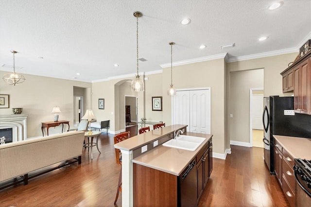 kitchen with pendant lighting, sink, a breakfast bar area, black dishwasher, and a center island with sink