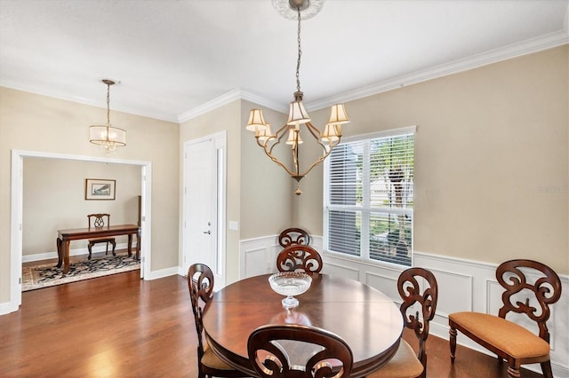 dining space with ornamental molding, dark wood-type flooring, and a chandelier