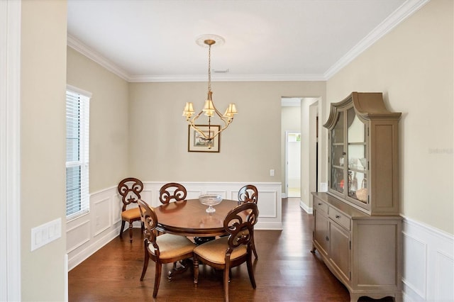 dining room featuring dark wood-type flooring, ornamental molding, and an inviting chandelier