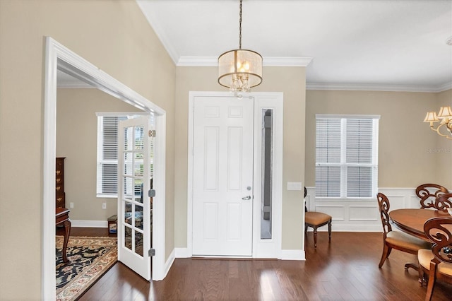 entrance foyer with crown molding, a notable chandelier, and dark hardwood / wood-style flooring