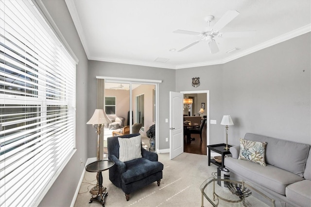 carpeted living room with ornamental molding and ceiling fan