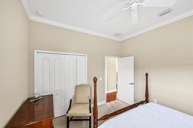 bedroom with ceiling fan, ornamental molding, carpet floors, and a closet