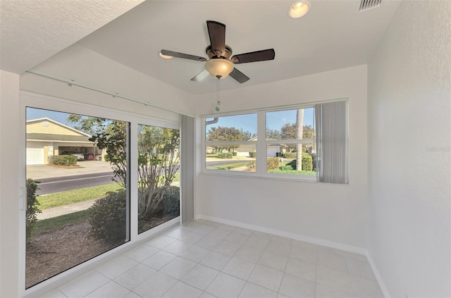 unfurnished sunroom featuring ceiling fan