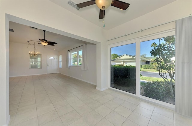 tiled spare room with vaulted ceiling and ceiling fan with notable chandelier